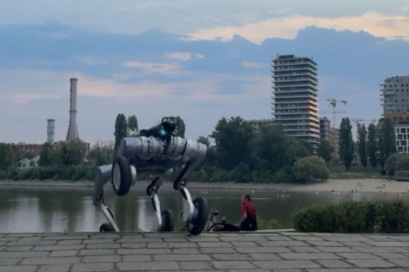 A wheel-legged Nortemsy robot on a paved riverside route in Budapest